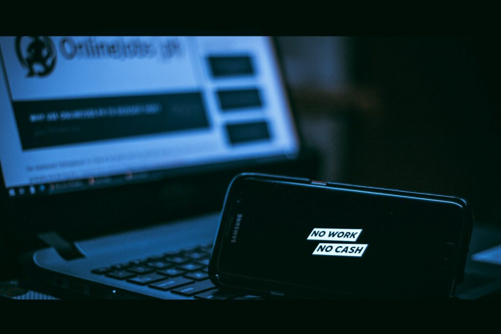Teléfono celular junto a una pantalla que representa una alerta de seguridad digital