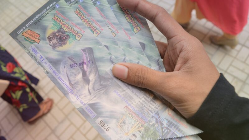 Boleto de lotería junto a números ganadores de un sorteo