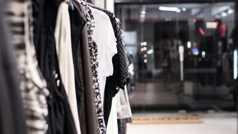 Interior de una tienda de moda con prendas exhibidas para clientes