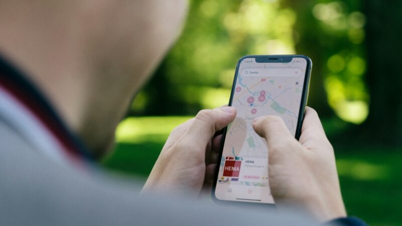 Persona utiliza un teléfono para buscar lugares y actividades en un mapa