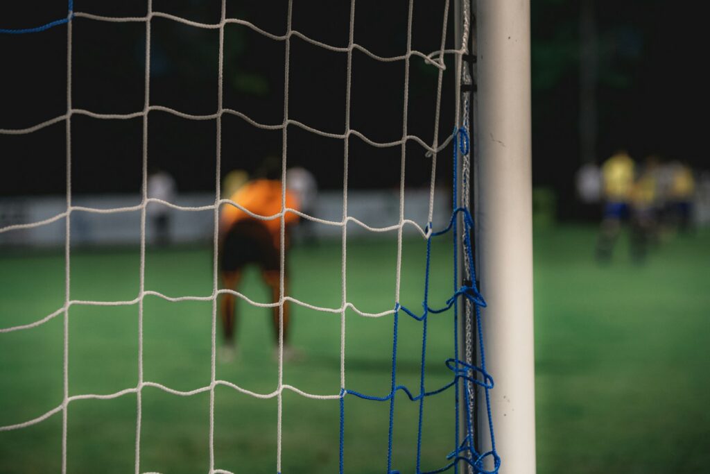 Arquero estirándose para detener un remate durante un partido de fútbol