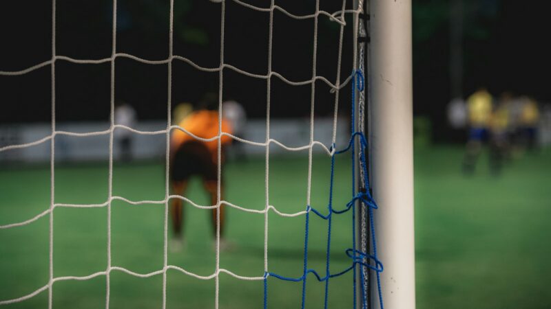Arquero estirándose para detener un remate durante un partido de fútbol