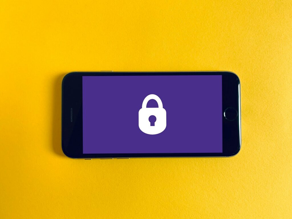 Un teléfono Android junto a una señal de alerta de seguridad en pantalla.
