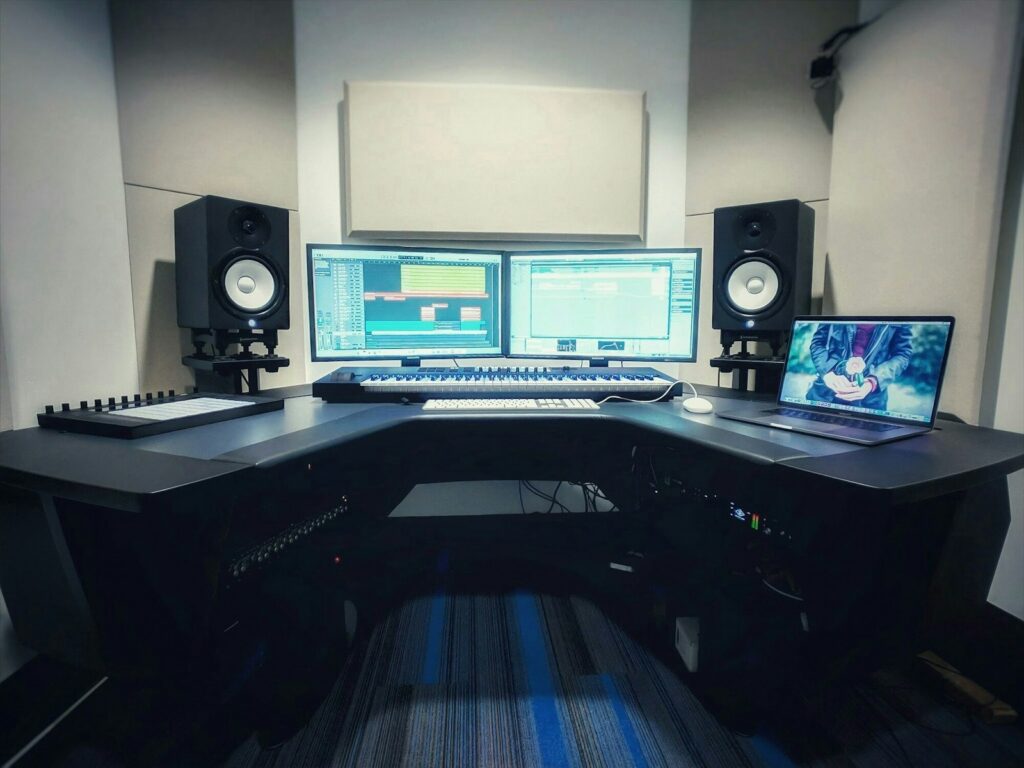 Un productor musical trabaja frente a una computadora con herramientas digitales para crear audio.