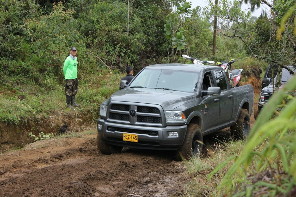 Obras de construcción de una carretera con maquinaria pesada y vehículos de carga.