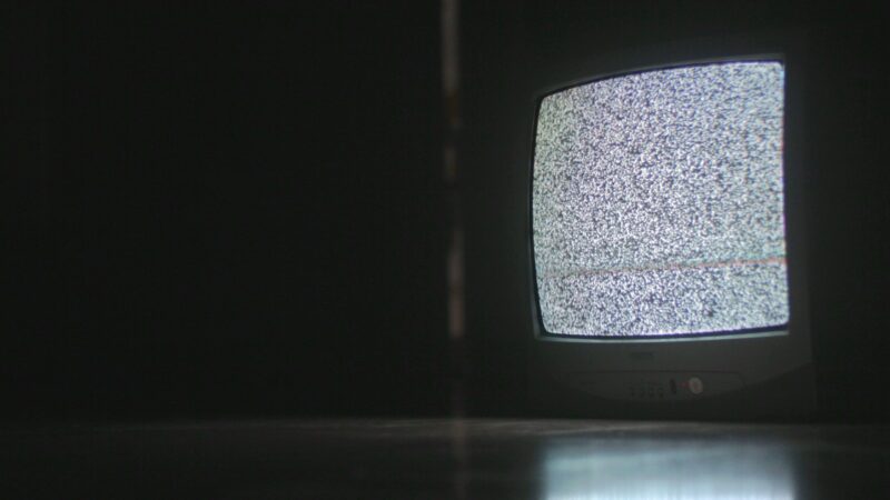 Televisión encendida en un ambiente oscuro, en ilustración alusiva a los estrenos de terror de la plataforma en octubre