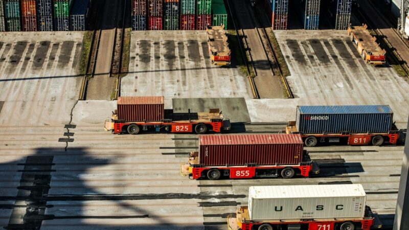 Contenedores de carga apilados en una terminal portuaria durante una operación de comercio internacional