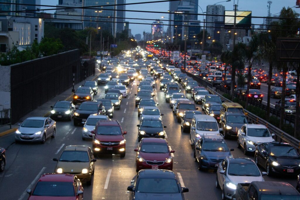 Vehículos circulan por una vía urbana con tráfico durante una jornada de movilidad