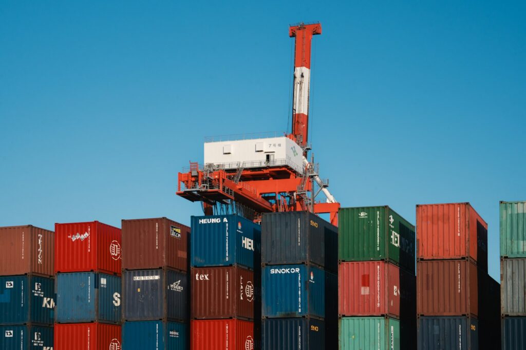 Contenedores de carga apilados en una terminal portuaria, una escena relacionada con el comercio exterior y las exportaciones.