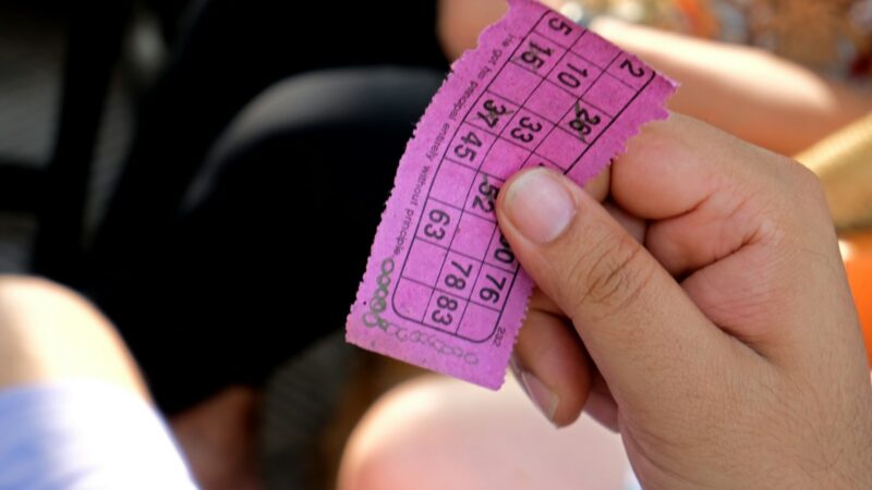 Balotas de lotería multicolores junto a un tiquete, imagen alusiva al sorteo del Baloto y su Revancha