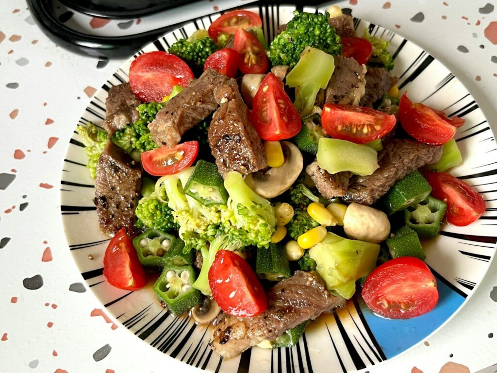 Plato de carne de res acompañado de legumbres, verduras y otros alimentos de una dieta equilibrada
