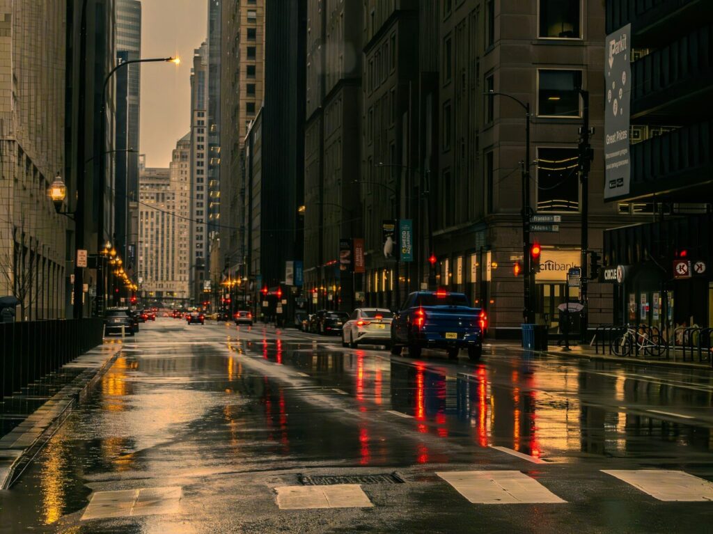 Vía urbana afectada por lluvia intensa y acumulación de agua mientras circulan vehículos