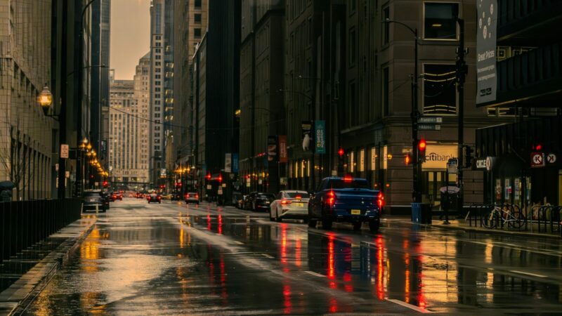 Vía urbana afectada por lluvia intensa y acumulación de agua mientras circulan vehículos
