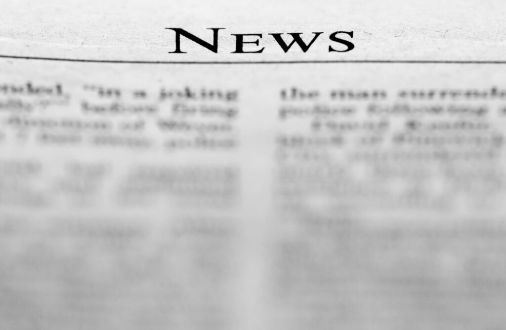 Periódicos y documentos sobre una mesa de noticias con información nacional e internacional