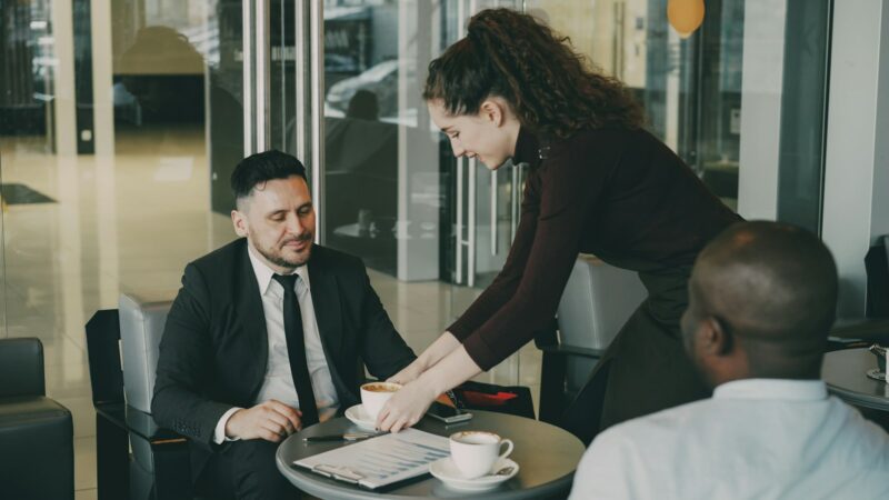 Asesor de seguros atendiendo a un cliente junto a un automóvil