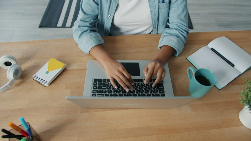 Persona trabajando con un computador portátil desde un espacio de oficina en casa