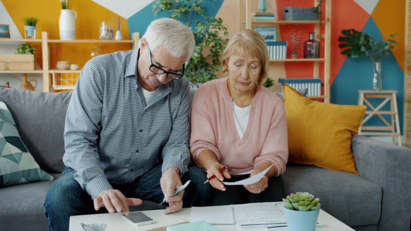 Adultos mayores reciben asesoría sobre servicios financieros en una oficina bancaria