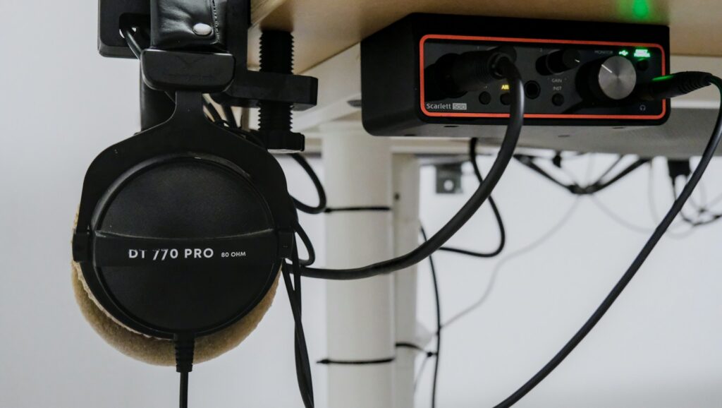 Auriculares con cable sobre una superficie junto a dispositivos tecnológicos