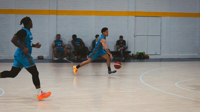 Jugadores disputando un partido de futsal en una cancha cubierta