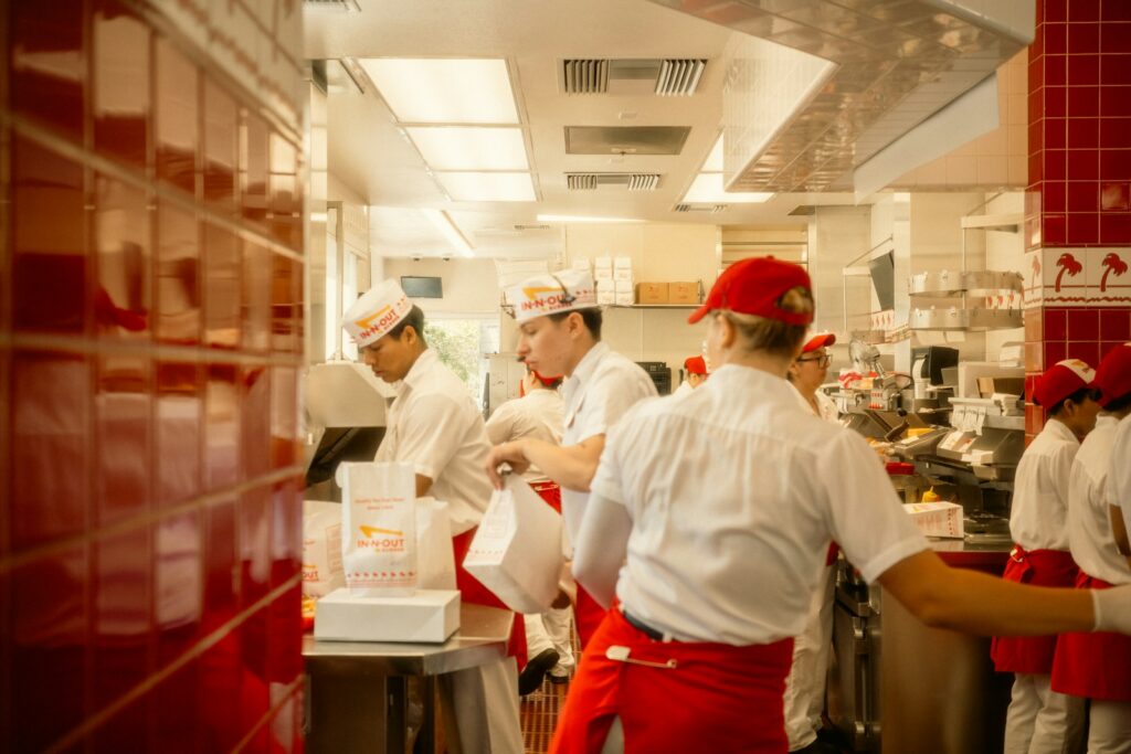 Interior de un restaurante con personal trabajando en la cocina y el área de servicio