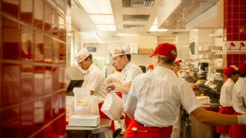 Interior de un restaurante con personal trabajando en la cocina y el área de servicio
