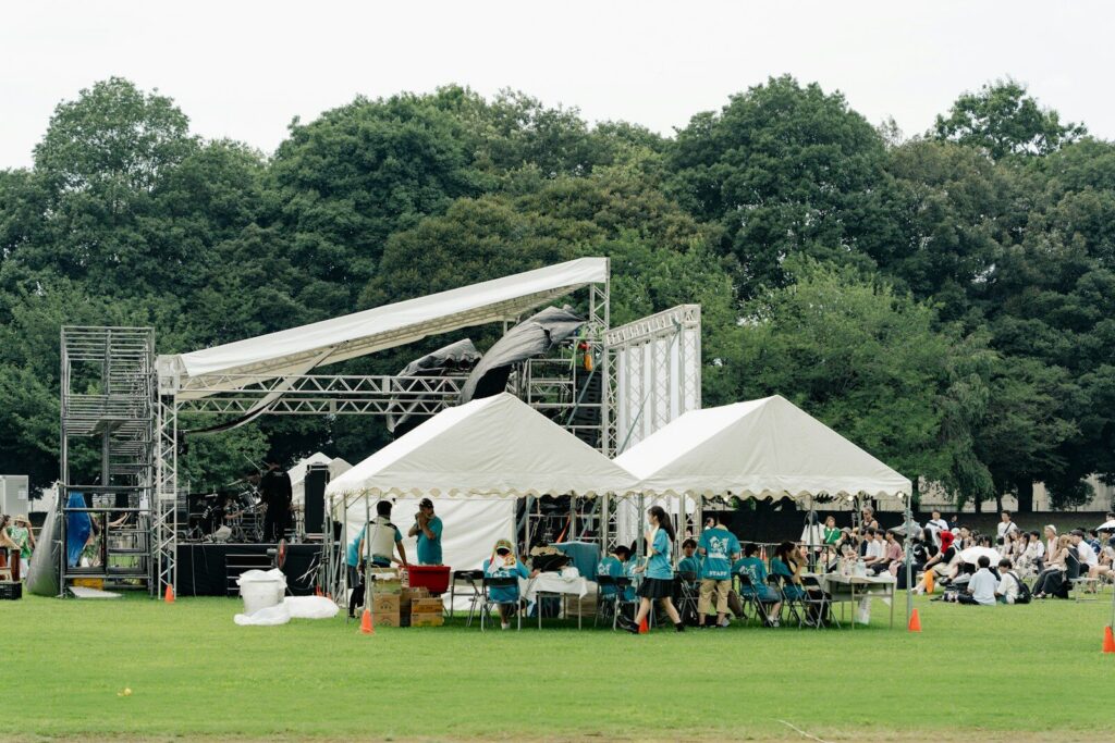 Público frente a un escenario durante un festival al aire libre con oferta gastronómica