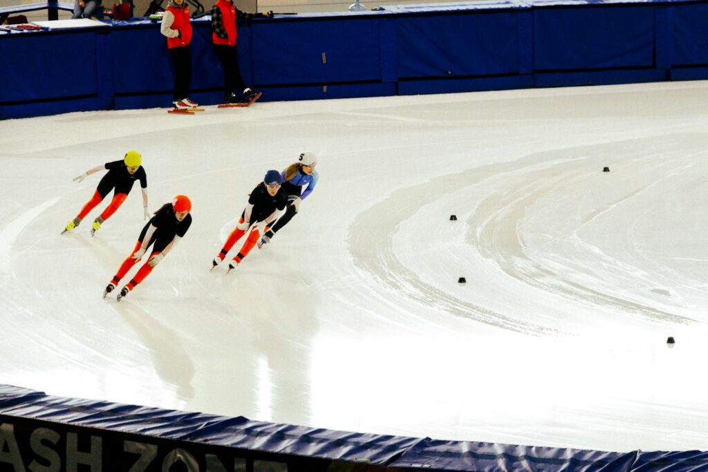 Patinadores compiten en una prueba de velocidad sobre una pista deportiva