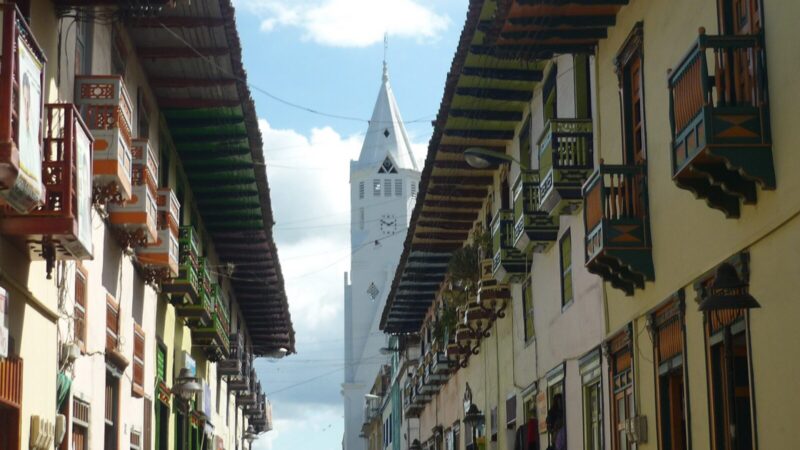 Paisaje montañoso del Eje Cafetero colombiano con vegetación y construcciones tradicionales